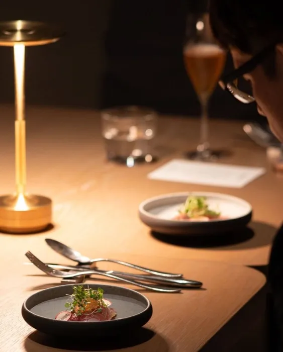 Une table dressée à la lumière d'une lampe